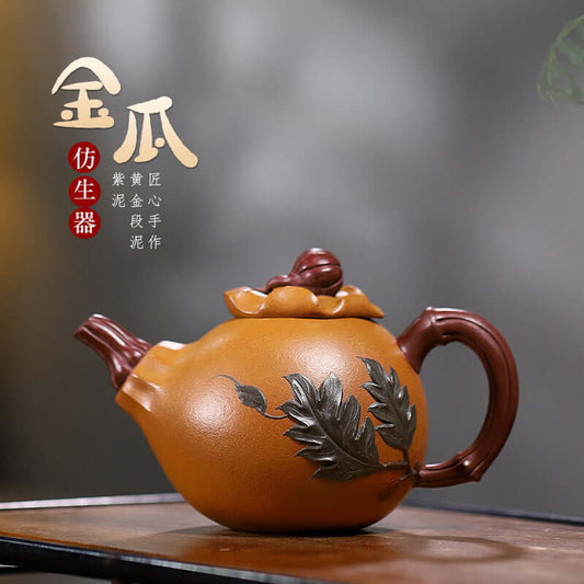 Handmade Yixing purple sand teapot designed in the shape of a gourd, featuring intricate leaf details and a warm orange color.