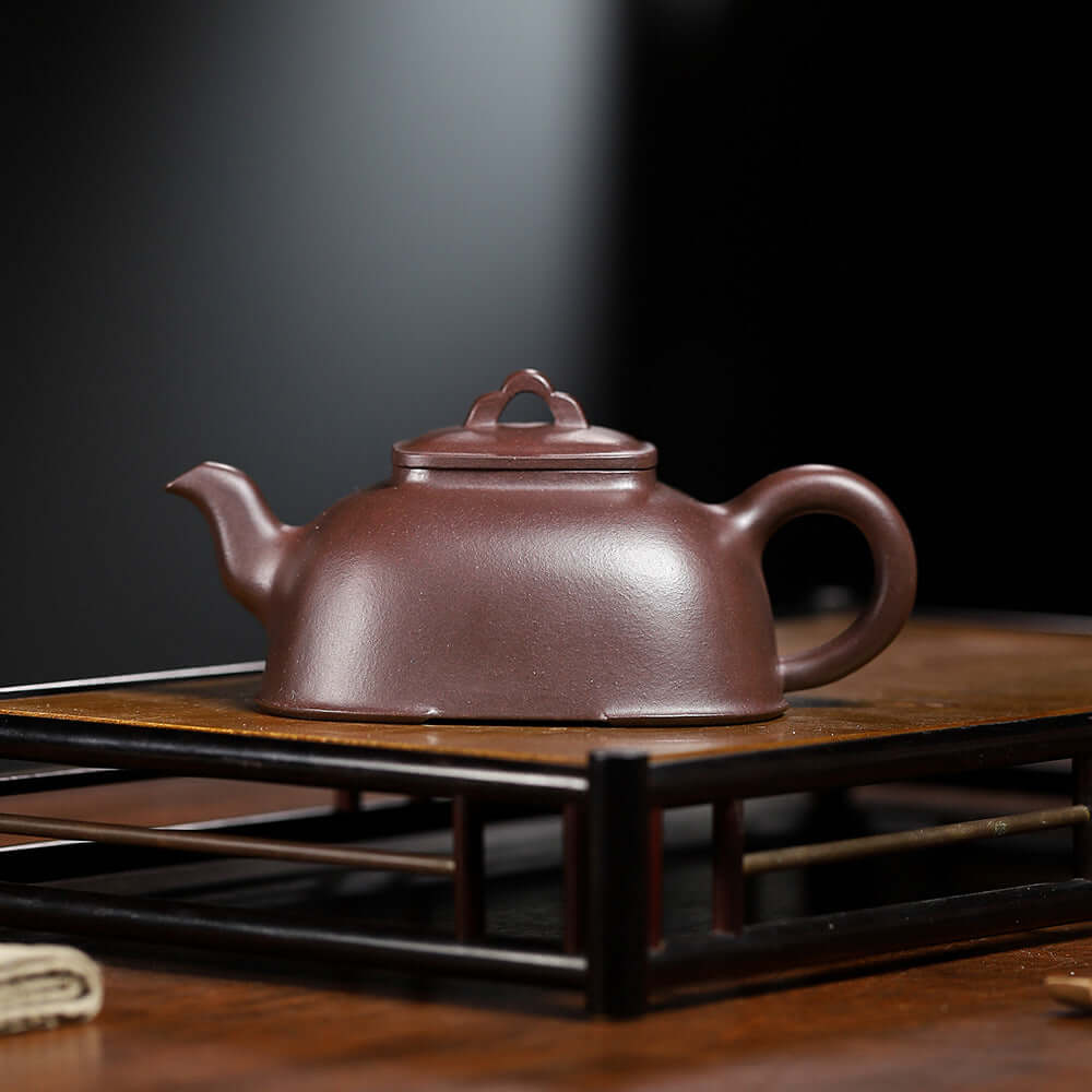 Handmade Yixing purple sand teapot on display, showcasing traditional craftsmanship and elegant design.