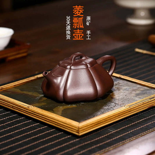 Handmade Yixing purple sand teapot on a wooden tray, showcasing fine craftsmanship and traditional design.