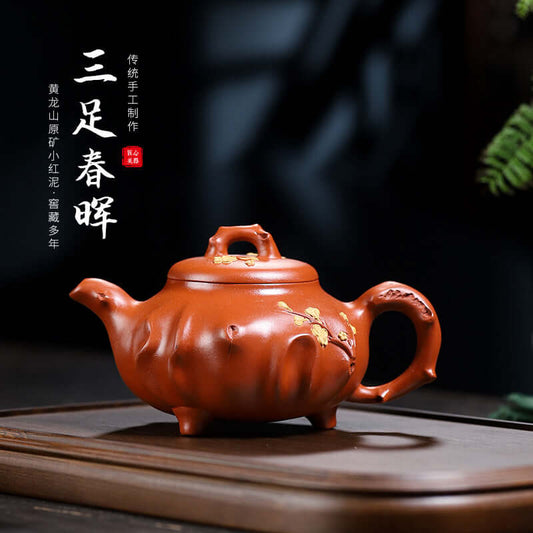 Handmade Yixing purple sand teapot, three-legged design, featuring intricate floral patterns, perfect for collectors.