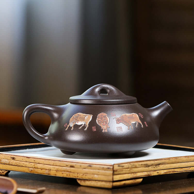 Handmade Yixing purple sand teapot with cow patterns, showcasing traditional craftsmanship and design.