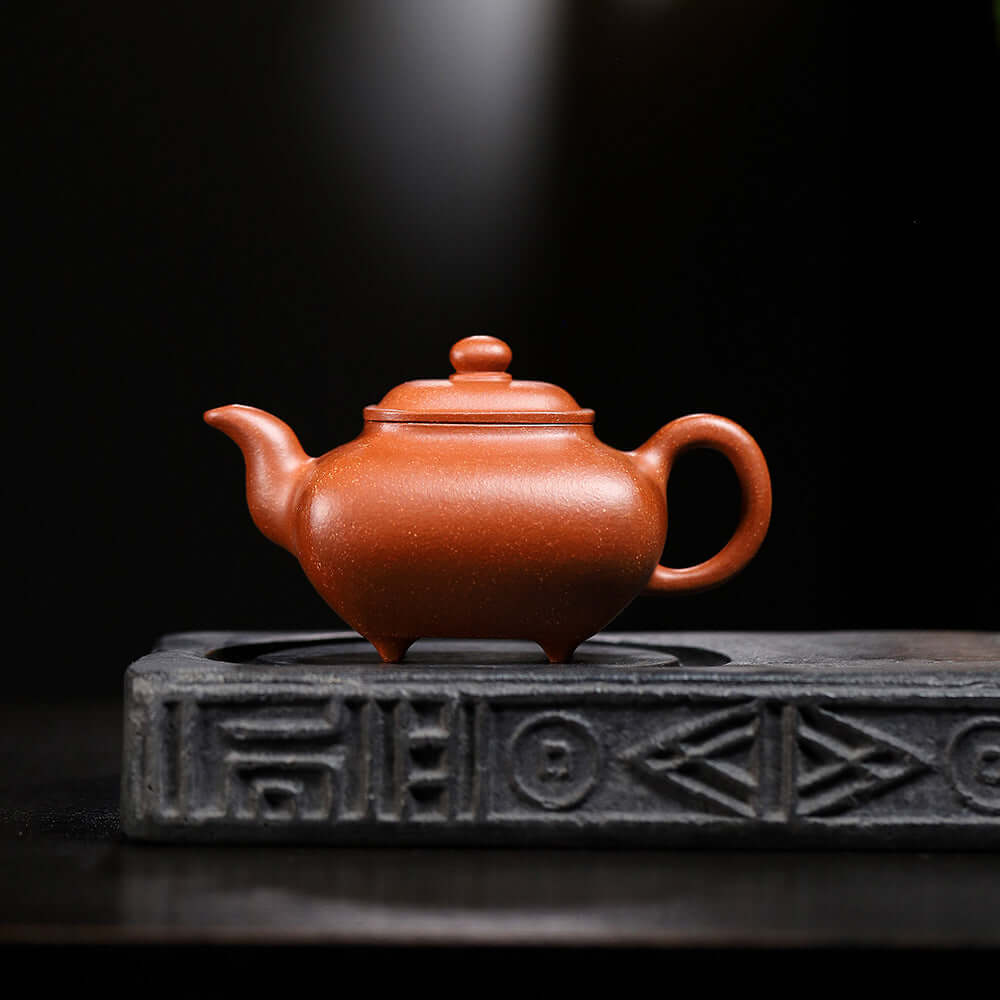 Handmade Yixing purple sand teapot on a tea tray, showcasing traditional craftsmanship and beautiful design.
