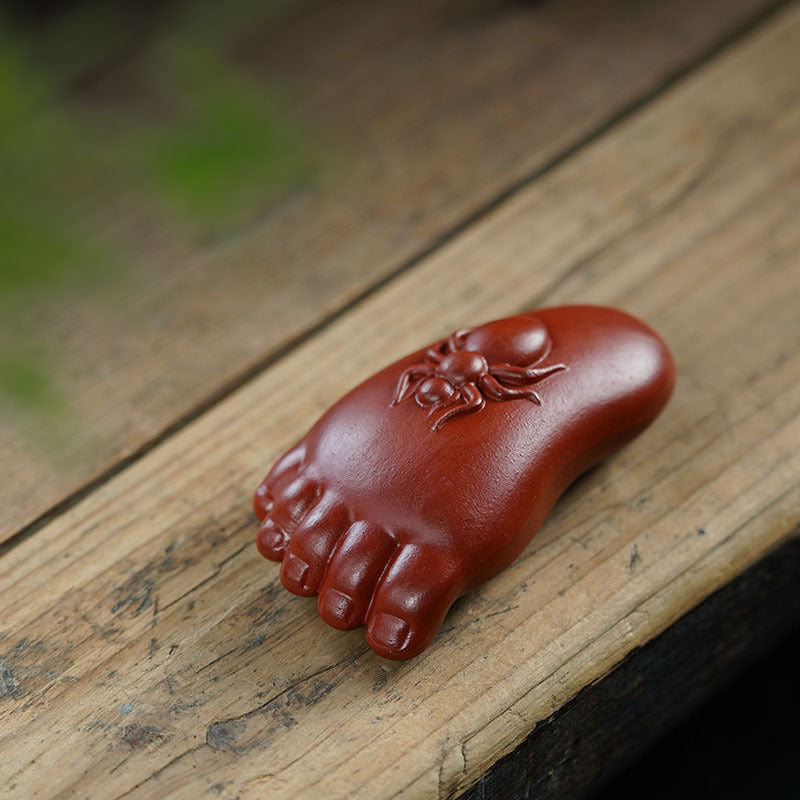 Handmade purple sand tea pet ornament, Changle Zhu Ni design, crafted by Yixing artisan, depicting a whimsical foot sculpture.