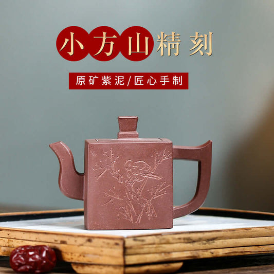 Handmade Yixing purple sand teapot, small square design with intricate engraving, showcasing traditional craftsmanship.