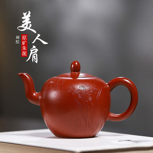 Handmade Yixing purple sand teapot with floral engraving, showcasing elegant craftsmanship and rich red clay.