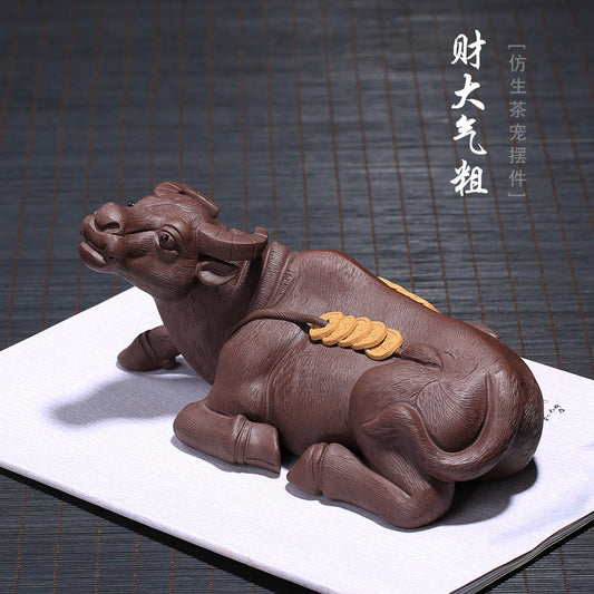 Handmade Yixing purple sand tea pet in the shape of a resting cow, symbolizing wealth and prosperity, crafted by skilled artisans.