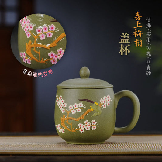 Handmade Yixing purple sand tea cup with floral design, traditional craftsmanship, unique green sand color.