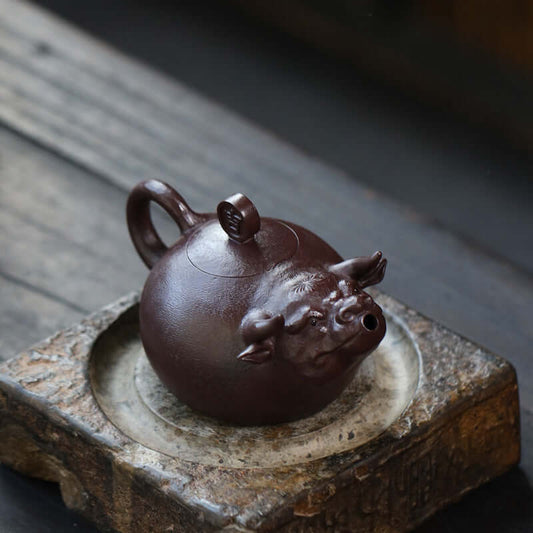 Handmade Yixing purple sand teapot crafted in the shape of a bull, showcasing intricate details and traditional design.