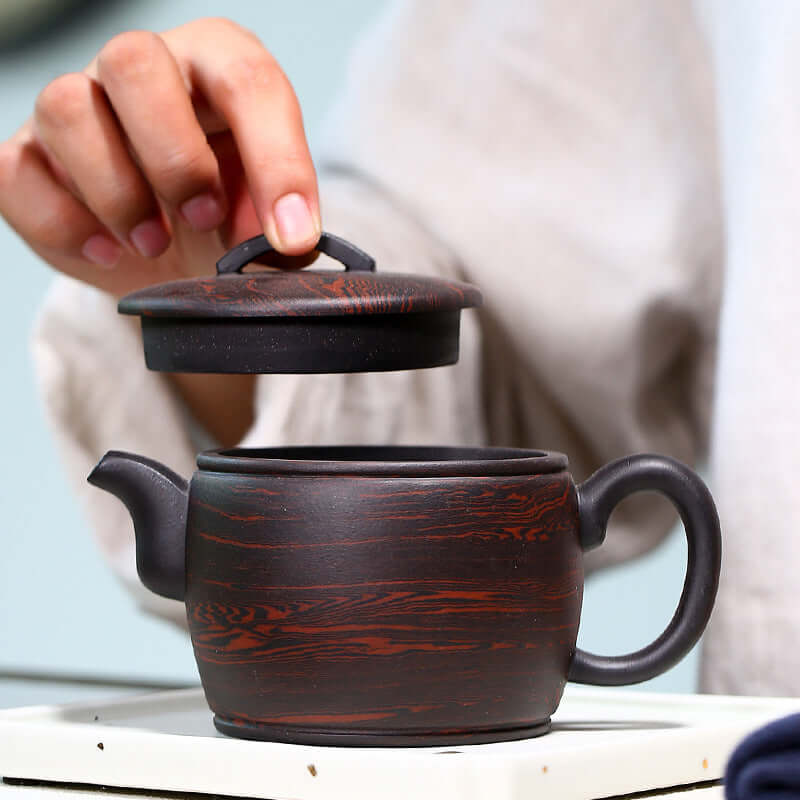 Handmade Yixing purple sand teapot with lid, showcasing traditional craftsmanship and unique design.