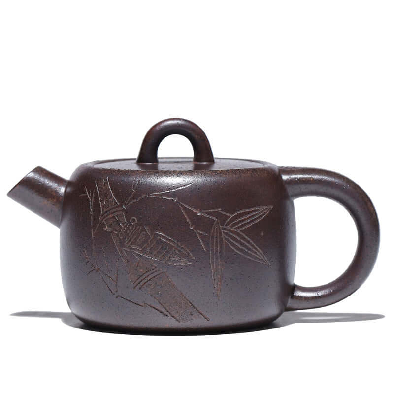 Handmade Yixing purple sand teapot with intricate insect and bamboo design, showcasing traditional craftsmanship.