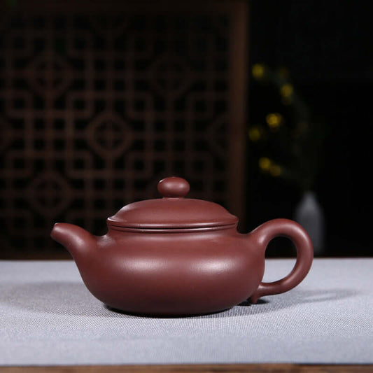 Handmade Yixing purple sand teapot, showcasing elegant design and craftsmanship, perfect for tea lovers.