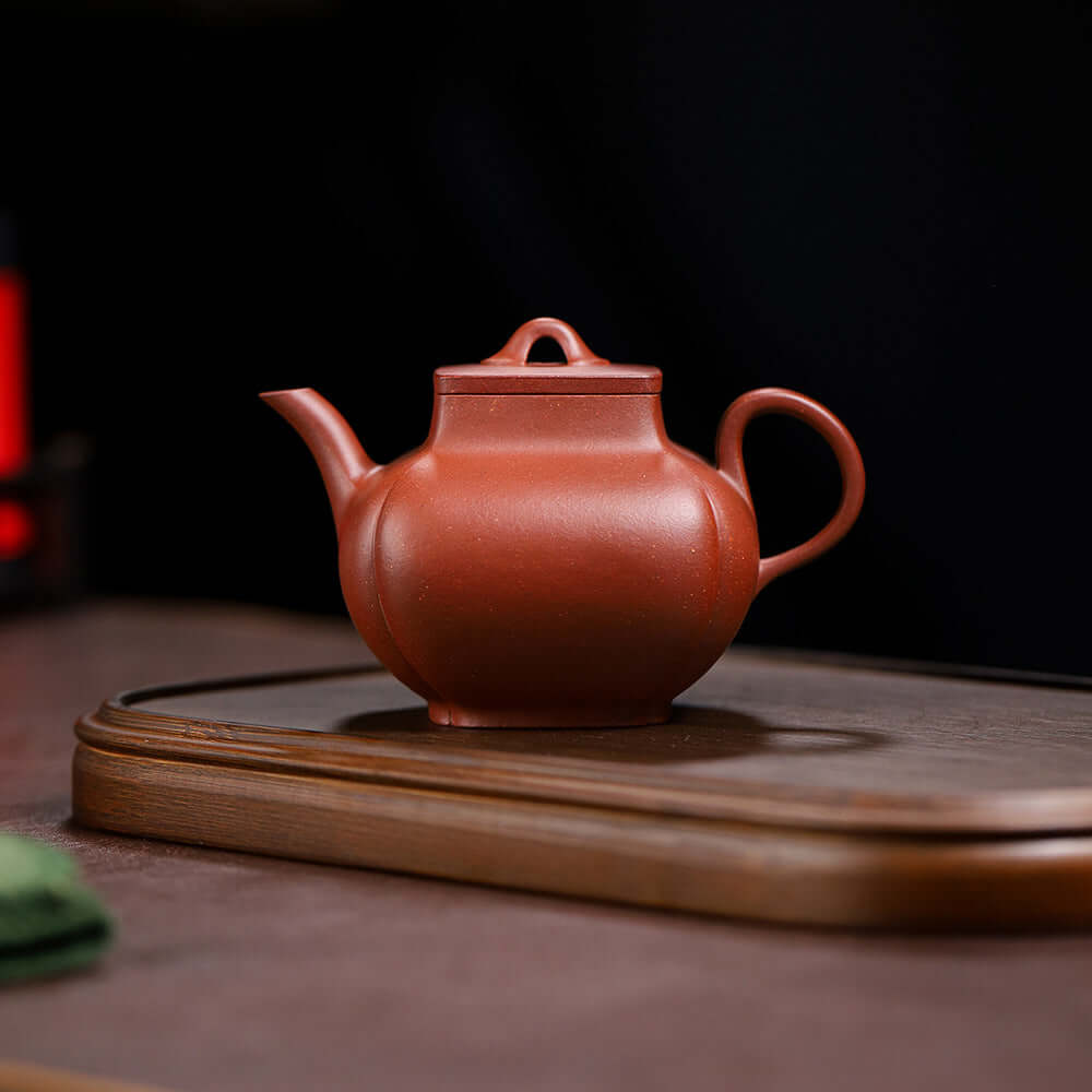 Handmade Yixing purple sand teapot on a wooden tray, showcasing high-end craftsmanship and original clay design.