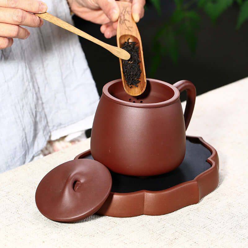 Handmade Yixing purple sand teapot with tea scoop, perfect for tea ceremonies and business gifts.