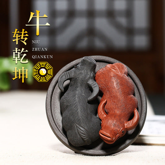 Handmade Yixing purple sand tea pet featuring black and red bull designs, symbolizing luck and harmony in tea ceremonies.