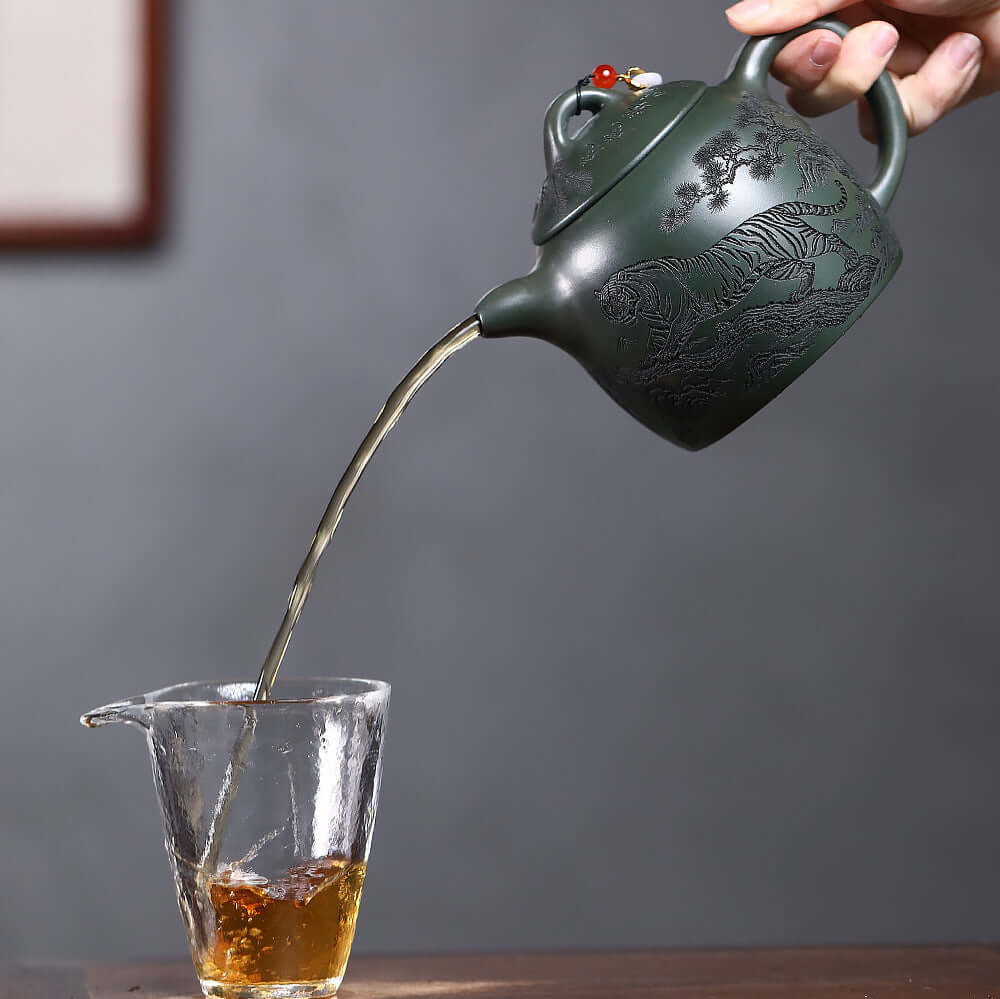 Handmade Yixing purple sand teapot pouring tea into a glass, showcasing original craftsmanship and large capacity.