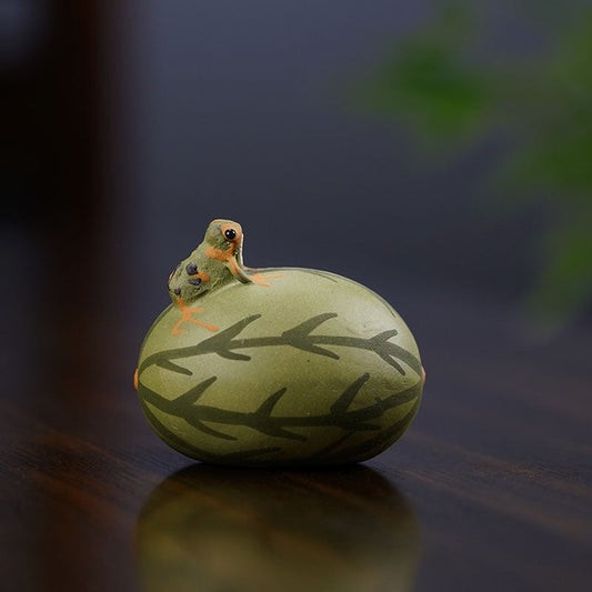 Handmade Yixing purple sand frog ornament on a tea pet, featuring a playful watermelon design.