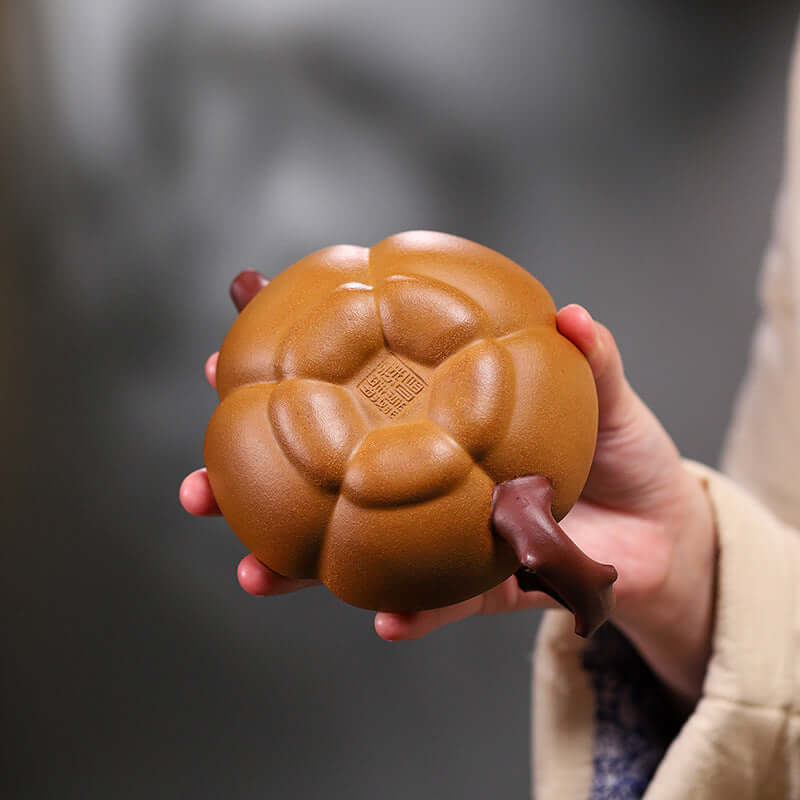 Handmade Yixing purple sand teapot shaped like a pumpkin, showcasing exquisite craftsmanship and unique design.