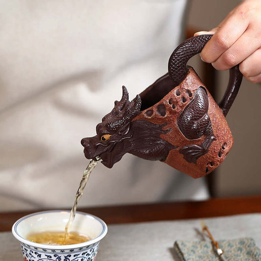 Handmade Yixing purple sand tea dispenser in dragon shape pouring tea into a traditional cup.