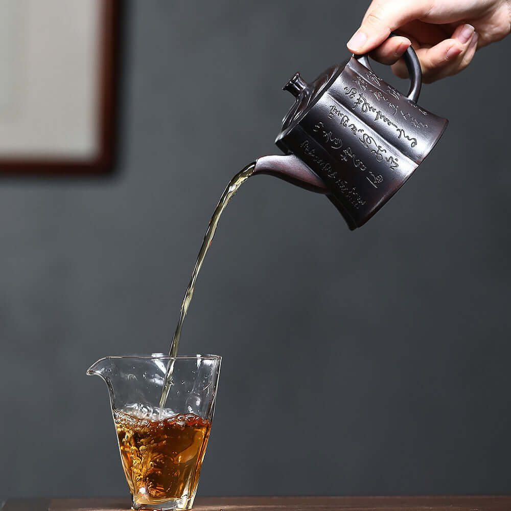 Handmade Yixing purple sand teapot pouring tea into glass, showcasing ancient craftsmanship and unique design.