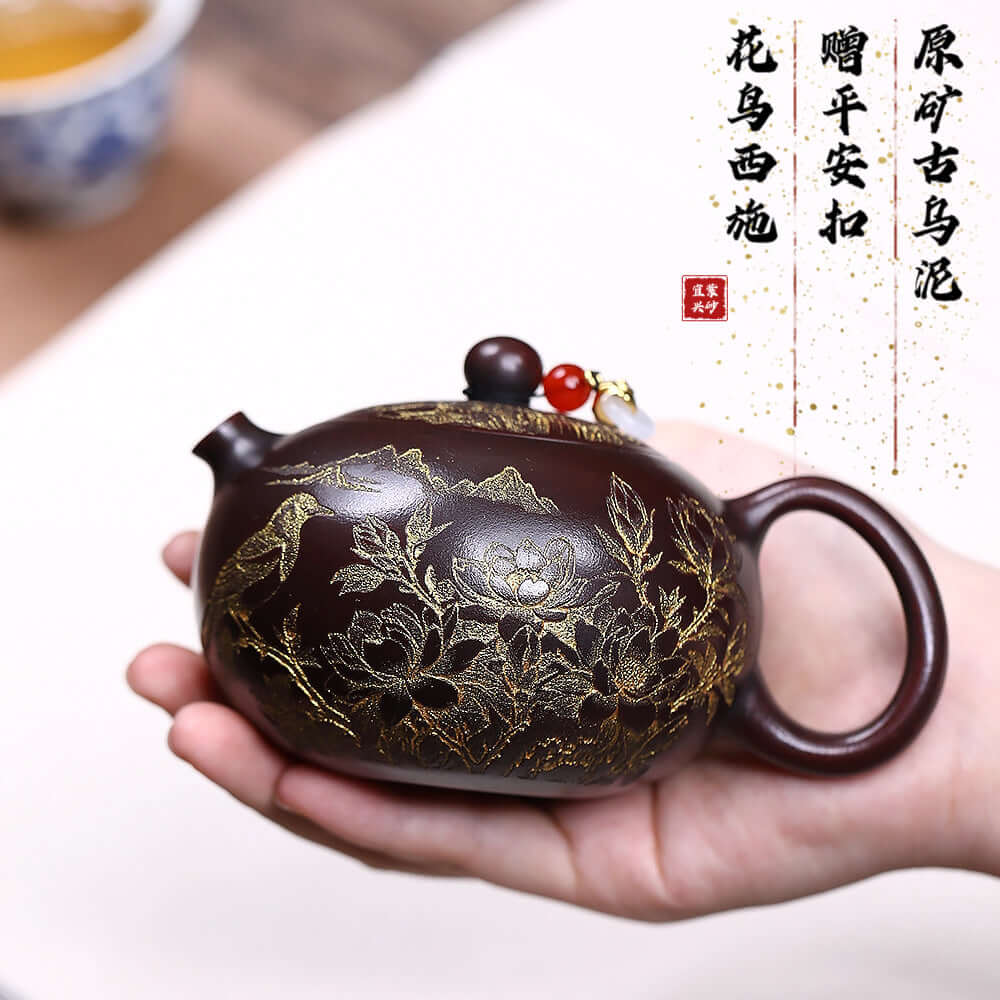 Handmade Yixing purple sand teapot featuring intricate floral and bird engravings, perfect for tea enthusiasts.