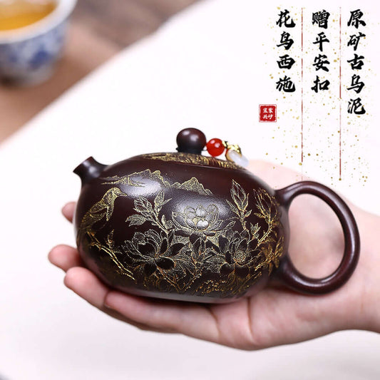 Handmade Yixing purple sand teapot featuring intricate floral and bird engravings, perfect for tea enthusiasts.