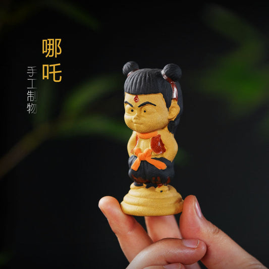 Handmade Yixing purple sand Nezha tea pet ornament crafted by artisan, perfect for tea lovers and collectors.