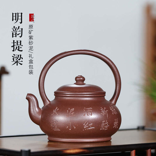 Handmade Yixing purple sand teapot with round handle, featuring elegant inscriptions and gift packaging.