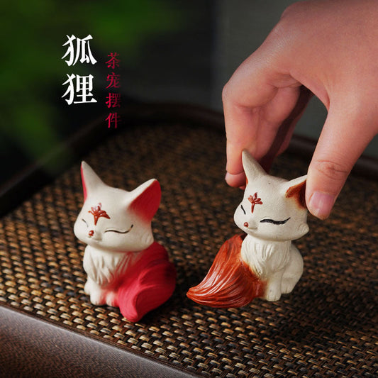 Handmade Yixing purple sand tea pet ornament, featuring a red and white nine-tailed fox, perfect for tea ceremonies and gifts.