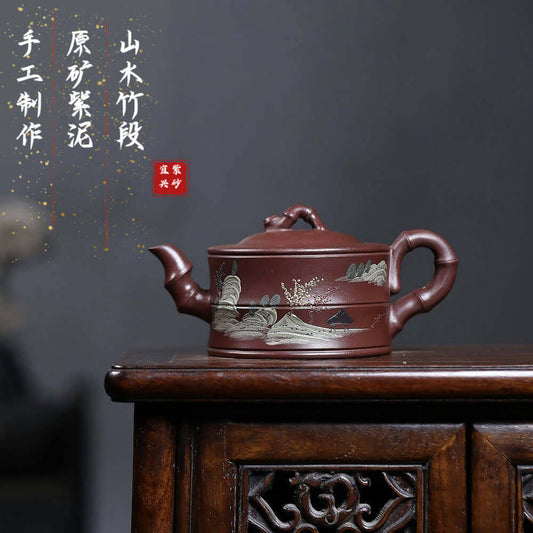 Handmade Yixing purple sand teapot with landscape design, crafted for kung fu tea sets, showcasing traditional artistry.