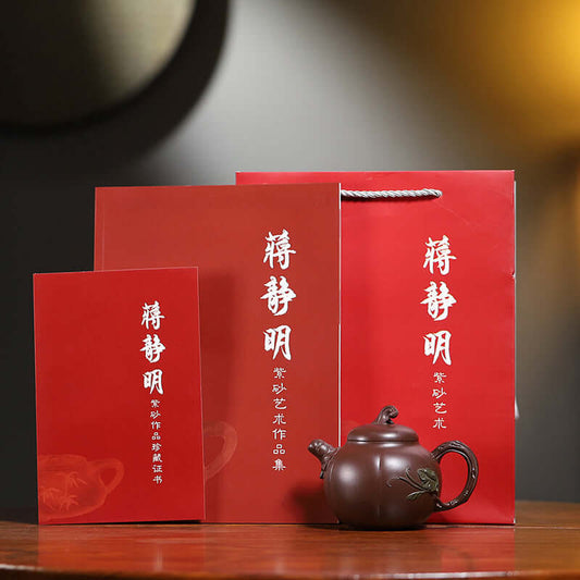 Handmade Yixing purple sand teapot with red packaging and certificates, showcasing artisan craftsmanship.