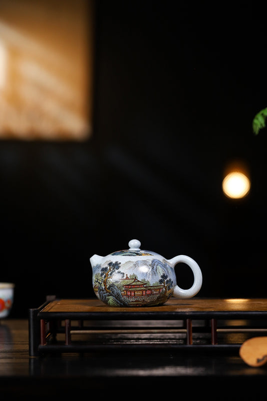 Handcrafted Yixing purple sand teapot with scenic design on a wooden tray, highlighting artisanal craftsmanship.