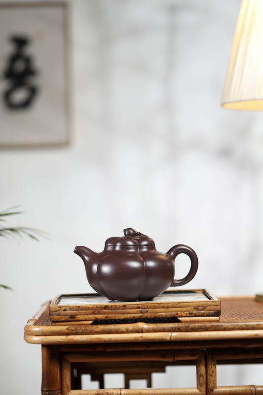 Handmade Yixing purple sand teapot in a traditional setting, showcasing elegant curves and craftsmanship.