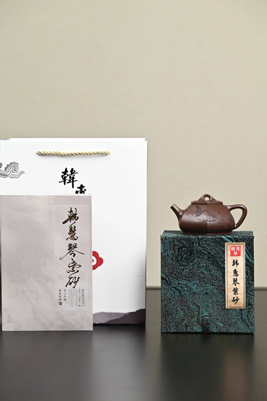 Handmade Yixing purple sand teapot displayed with elegant packaging and documentation.