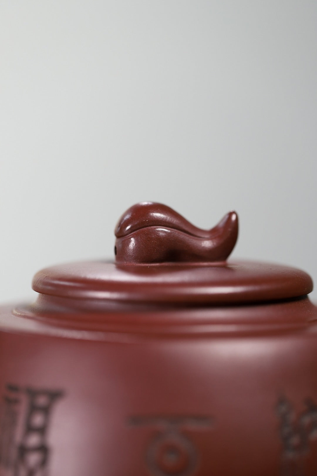 Top view of a handmade Yixing purple sand teapot lid with a decorative finial, showcasing fine craftsmanship.