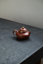 容天·全手工 /容量200cc/紫泥包金 壶身饱满圆容，恰如人的内心，大肚能容常人难容之事