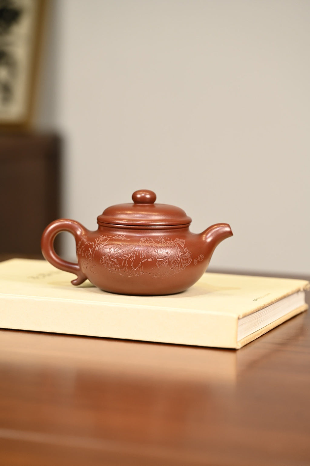 仿古·手工 /容量340cc/龙血砂 壶体在扁圆中求韵味，流把气韵相通，玉润饱满，干净纯粹，琢砂装饰，古味十足。