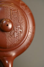 仿古·手工 /容量340cc/龙血砂 壶体在扁圆中求韵味，流把气韵相通，玉润饱满，干净纯粹，琢砂装饰，古味十足。