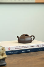 午禾·全手工 /实力派陶手東舒作品 /容量180cc/紫泥铺砂 器身矮扁，呈六方之态，线面挺括，上敛下阔有势