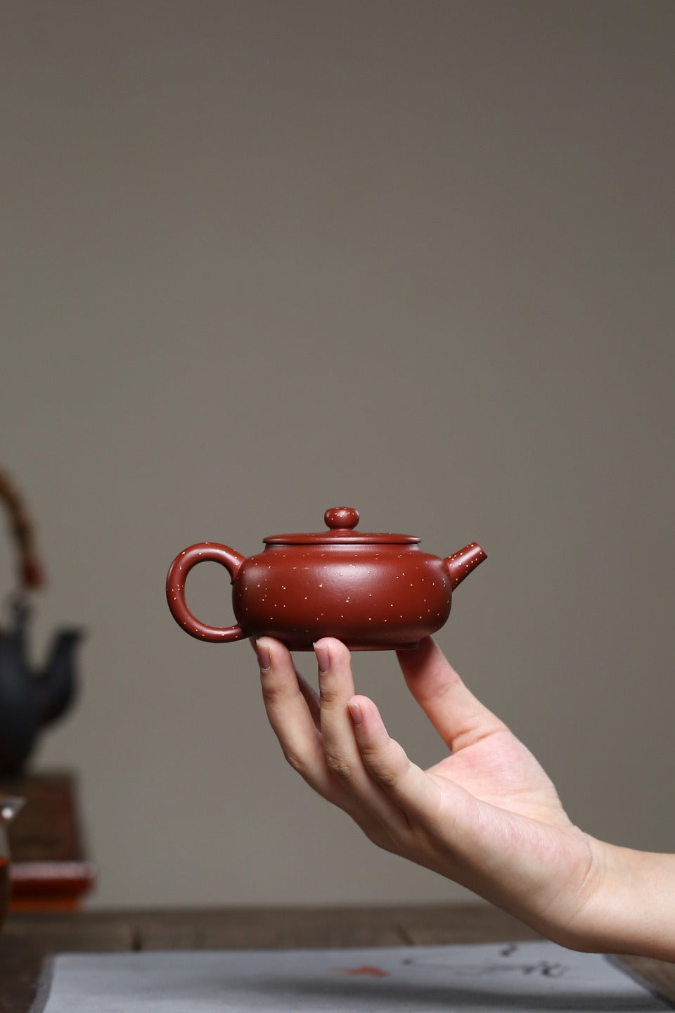 全手工【铺砂周盘】 制壶：殷俊雅（国家级工艺美术员） 泥料：原矿铺砂朱泥 容量：120cc 孔数：7孔