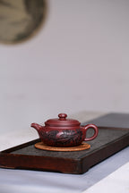 研高收藏重器【扁腹】 作者：刘红仙 职称：研究员级高级工艺美术师 刻绘：浮雕第一人张黎强 容量：520cc 泥料： 稀有紫红玉砂