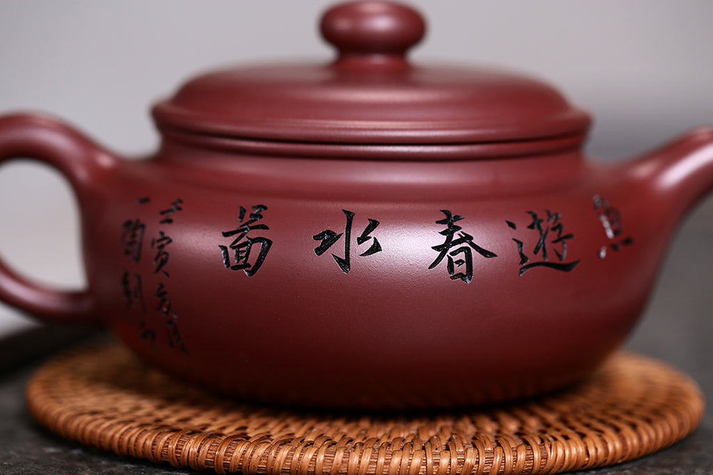 研高收藏重器【扁腹】 作者：刘红仙 职称：研究员级高级工艺美术师 刻绘：浮雕第一人张黎强 容量：520cc 泥料： 稀有紫红玉砂