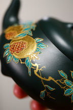Chinese purple clay teapot with gold and silver inlay showcasing exquisite floral design details.