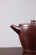 【瓦当】 泥料：紫朱泥 容量：200毫升 作者：陈菊华  此款光素瓦当壶，借鉴古瓦当形制，壶身筒形规整