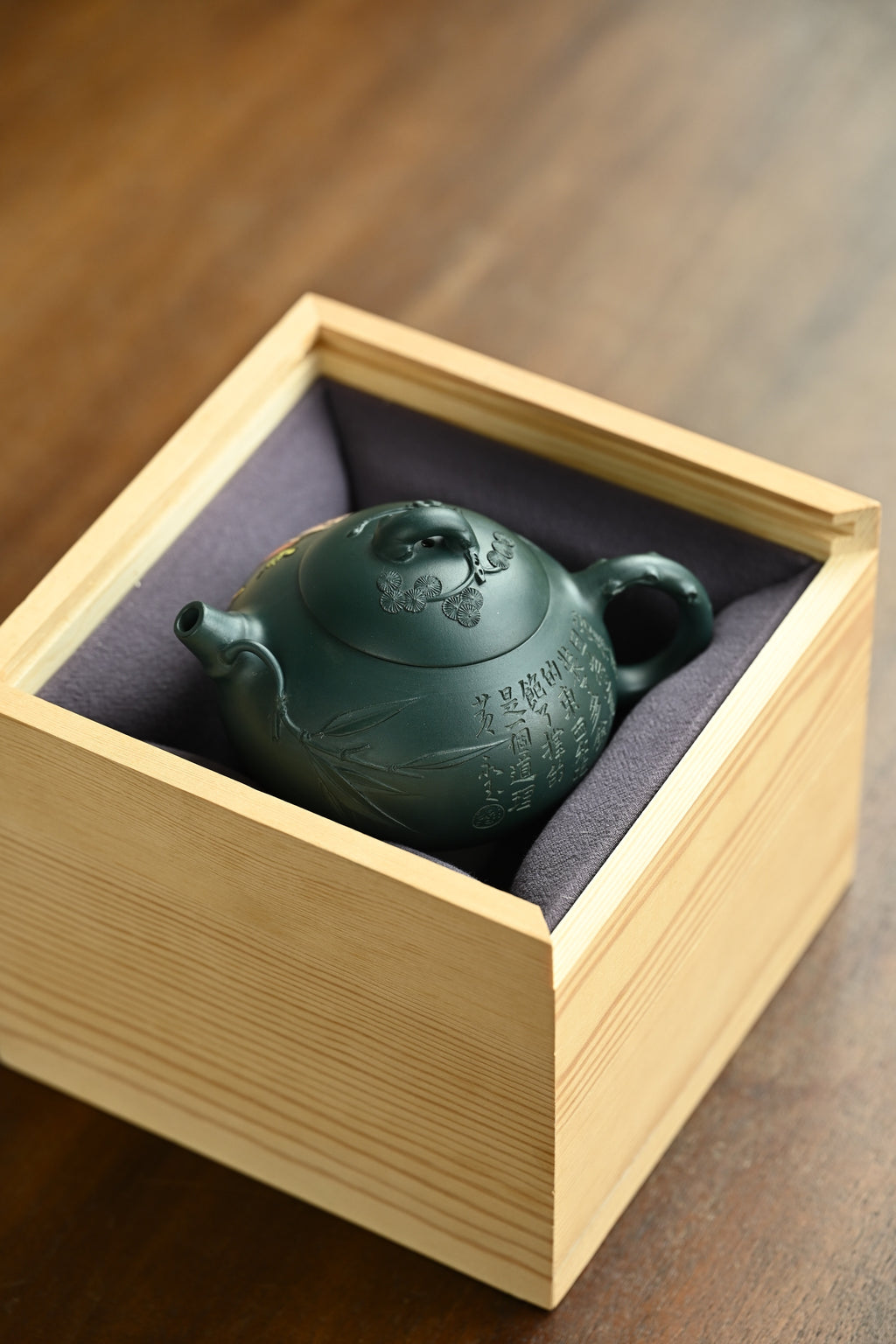 喜乐生财·全手工/容量280cc/一厂墨绿泥 壶身圆润饱满，片片竹叶覆于壶身之上，盖面松针坚韧，梅花傲然绽放