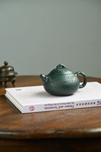 喜乐生财·全手工/容量280cc/一厂墨绿泥 壶身圆润饱满，片片竹叶覆于壶身之上，盖面松针坚韧，梅花傲然绽放