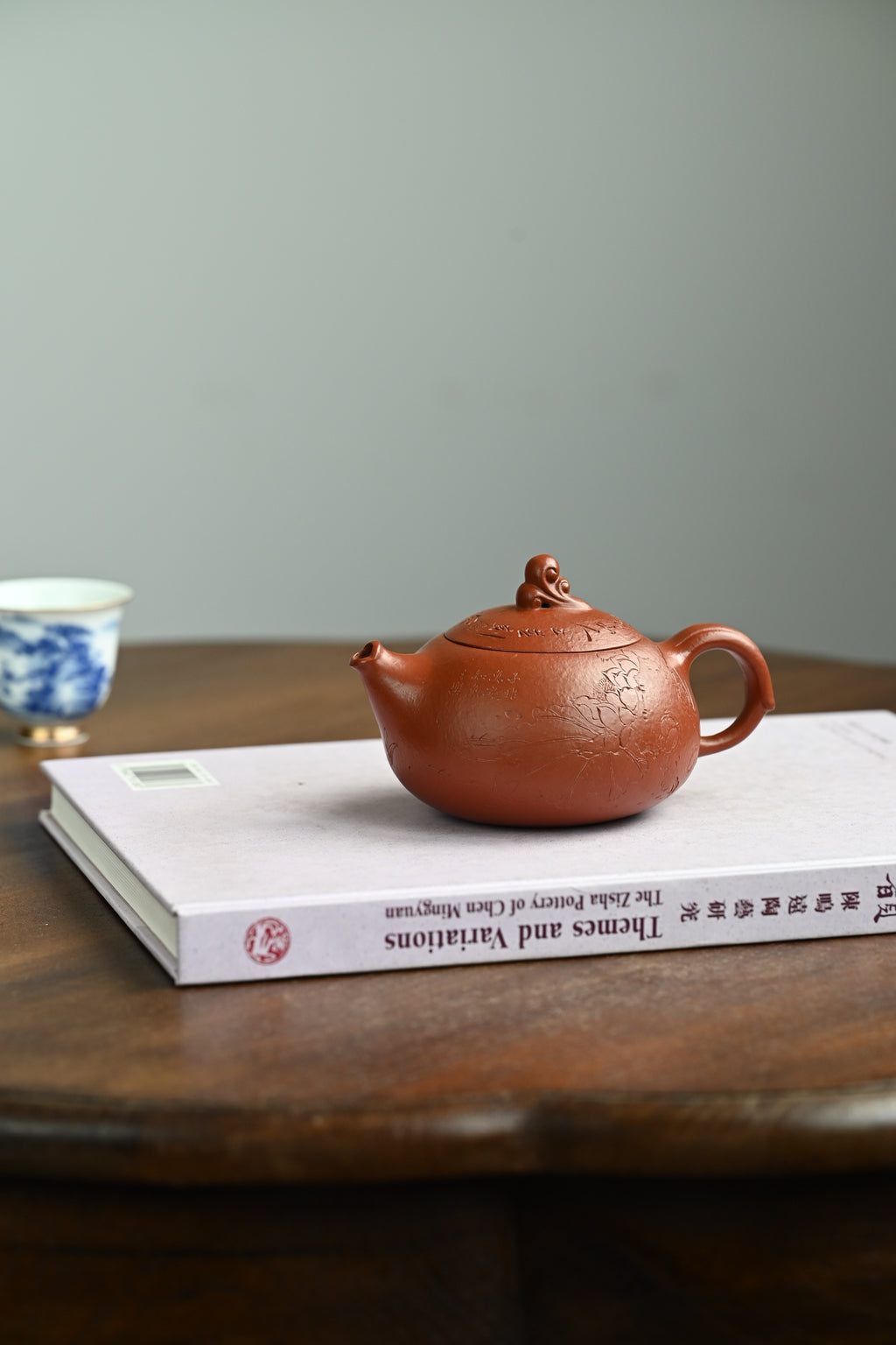 鱼跃清波·全手工/景舟杯金奖省名人研高何叶作品  /容量250cc/原矿大红袍 壶身体态丰腴柔和，壶钮塑作灵鱼戏水，灵动俏皮