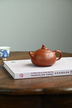 鱼跃清波·全手工/景舟杯金奖省名人研高何叶作品  /容量250cc/原矿大红袍 壶身体态丰腴柔和，壶钮塑作灵鱼戏水，灵动俏皮
