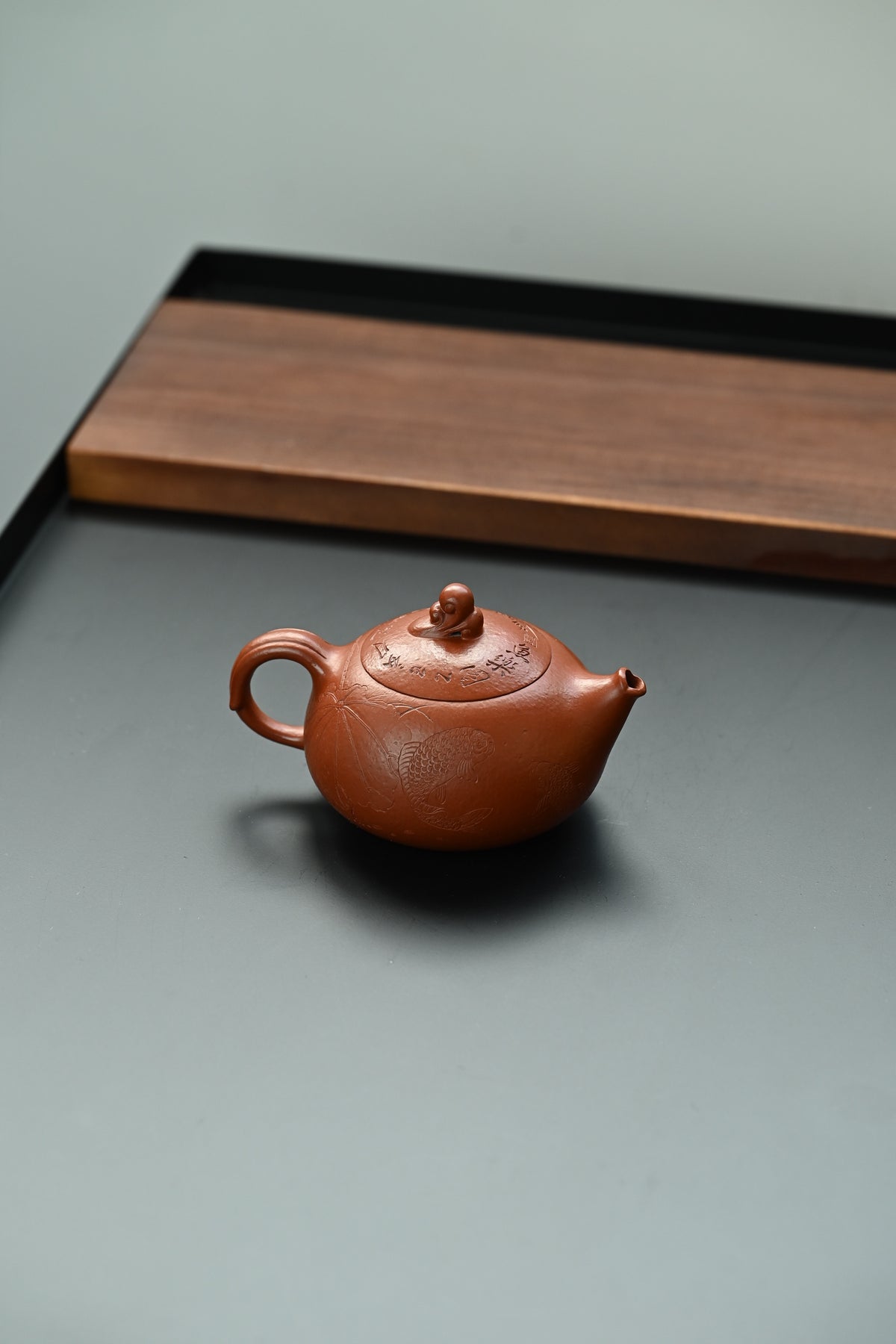 鱼跃清波·全手工/景舟杯金奖省名人研高何叶作品  /容量250cc/原矿大红袍 壶身体态丰腴柔和，壶钮塑作灵鱼戏水，灵动俏皮