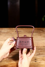 独家方形提梁美器【江山如画】原矿紫泥制 380cc，四方壶型大方得体，稳重有度。壶身刻绘江山图，提梁横跨壶肩两端，气势恢宏！